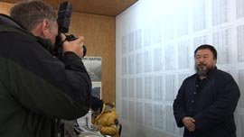 A foreign reporter photographs Ai Weiwei in front of the list of names of thousands of student earthquake victims, at his studio in Beijing.