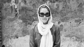 Heather in front of wall with Farsi graffiti