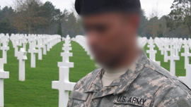A soldier pays his respects at the American cemetery in Normandy, France