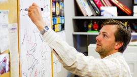 Dr. Ben Kilminister (particle physics researcher) at his whiteboard