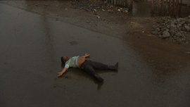 A man sleeps on a street in Carmen’s village