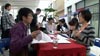 Wan Chao presents his CV at a job fair.