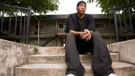 Chas sits on the steps of his apartment