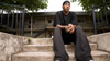 Chas sits on the steps of his apartment