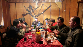 Hunters chatting around a well-laden table Hunters chatting around a well-laden table