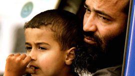 Abu Amar al Azzam waiting with his son Abu Bakr al Azzam in their van