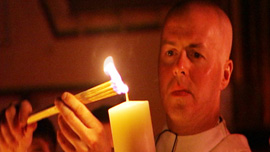 Father Paul O’Brien, Parish Priest at Saint Patrick Parish, Lawrence, MA, lights candle at Easter Vigil
