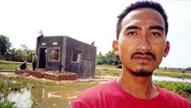 Loeun Lun in front of his new home in Siem Reap, Cambodia