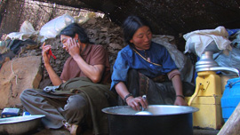 Yama churns butter as Locho attends to his skin care regimen