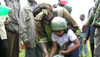 Maathai helps a young girl water the land in the Aberdare Forest, Kenya