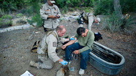 Border Patrol agents help an ailing migrant crosser