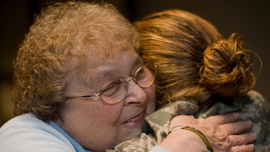 Joan Gaudet gives a hug to a returning soldier