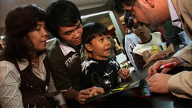 Naif Al-Mutawa signing a comic for a young fan in Jakarta