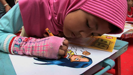 Indonesian girl coloring in a sketch of Noora The Light 