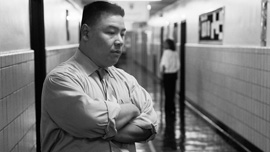 Principal Tom deliberates while standing in the school hallway