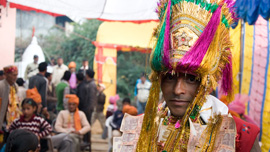 Hari poses wearing his wedding turban with guests in the background.