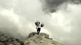 Everyday miners carry heavy loads of sulfur up and day the volcano.