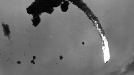 Japanese plane, hit by anti-aircraft fire from a U.S. carrier, plunges towards the water during an attack