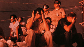 Personnel in the pre-dawn glare of an atomic test in the Greenhouse Series at Enewetok Atoll, 1951