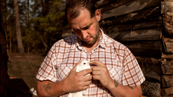 farmer and veteran Alex Sutton holding bird